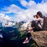Bessere Naturfotografie: Ein Fotograf sitzt auf einer Klippe