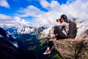 Bessere Naturfotografie: Ein Fotograf sitzt auf einer Klippe