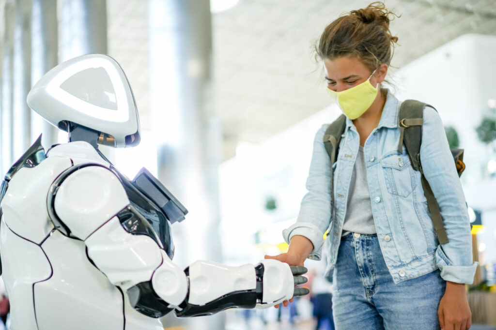 Zu wenig Arbeitskräfte – wie kann die Digitalisierung helfen? Ein Roboter begrüßt eine junge Frau