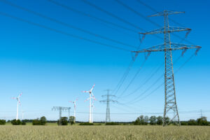 Von der Energiewende zur Energiekrise? Strommasten und Windräder nebeneinander.