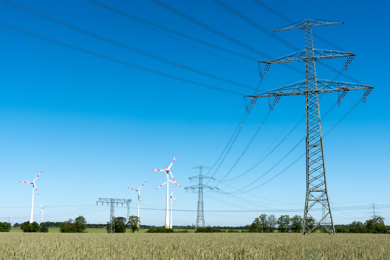 Von der Energiewende zur Energiekrise? Strommasten und Windräder nebeneinander.
