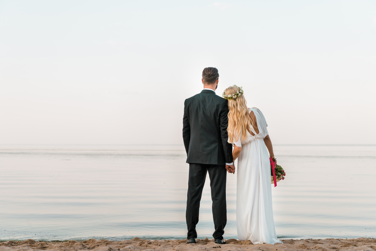 Die Unterschiede zwischen evangelischer und katholischer Hochzeit: ein Ehepaar am Strand.